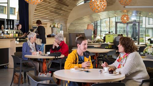 Mensen drinken koffie in het paviljoen Mensen drinken koffie in het paviljoen